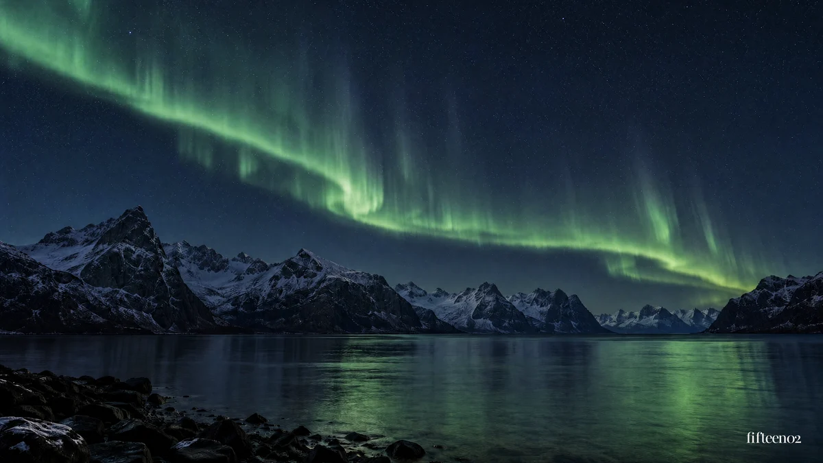 Green aurora reflected in a quiet mountain fjord, with a small fifteen02 wordmark.